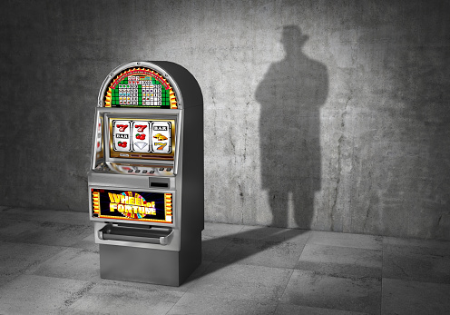 gambling-concept-ludomania-slot-machine-cast-shadow-in-form-gangster-picture-id944519472